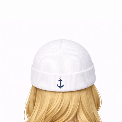 White beanie with an anchor emblem worn by a person with blonde hair on a white background